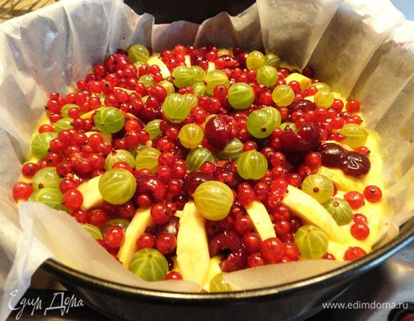 Круглую разъемную форму застелить бумагой для выпечки и смазать сливочным маслом. Выложить тесто, разровнять лопаткой. Сверху в творческом беспорядке выкладываем ягодки. Посыпаем 2-3 столовыми ложками сахара.