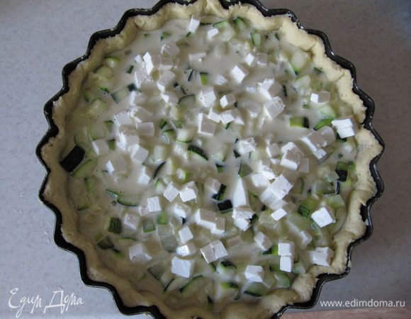 Слегка взбить 2 яйца со сливками. Добавить соль, черный молотый перец, щепотку мускатного ореха и кабачки. Перемешать. Начинку вылить на подпеченное тесто, сверху выложить нарезанную кубиками фету.
Вернуть тарт в духовку на 25 мин.