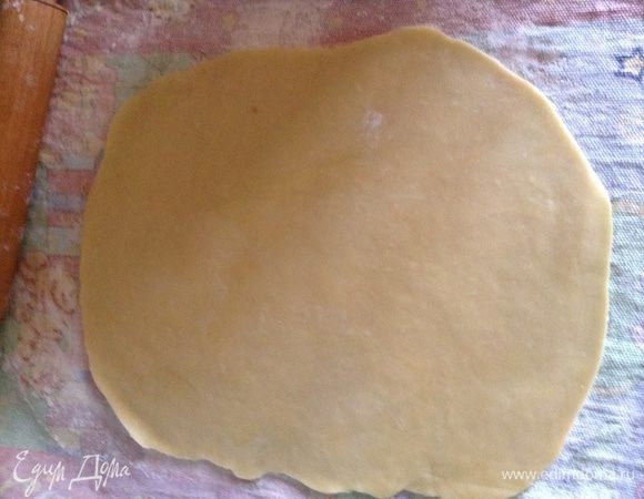 Большое кухонное полотенце присыпать обильно мукой, выложить тесто и скалкой, смазанной маслом, раскатать как можно тоньше.