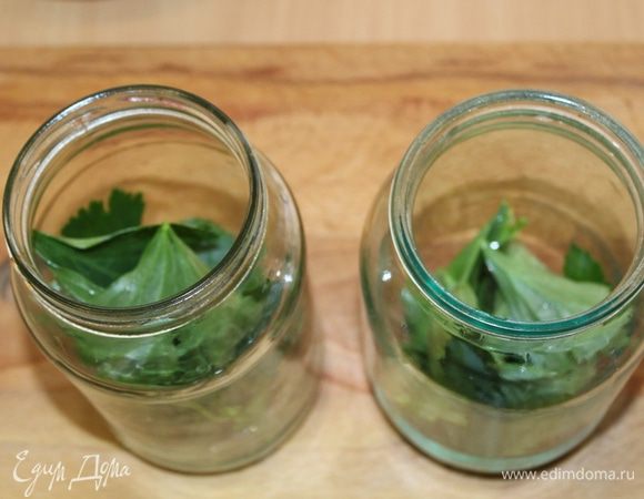 На дно стерилизованной банки положить ветку листового сельдерея, несколько зубчиков чеснока.