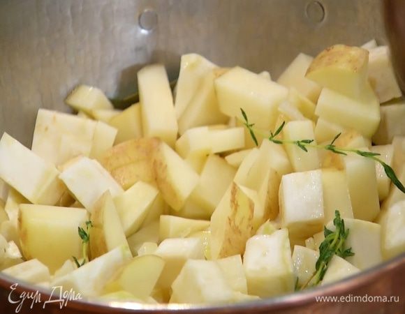 Картофель вымыть и, не очищая, нарезать маленькими кубиками, затем добавить в кастрюлю, все перемешать и продолжать готовить под крышкой.