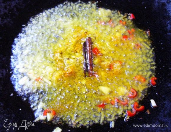 В сковороде вок прогреть оливковое масло, добавить кардамон, тмин, корицу, куркуму, чили, имбирь, чеснок. Подержать на огне 1 мин, чтобы ароматы раскрылись.
