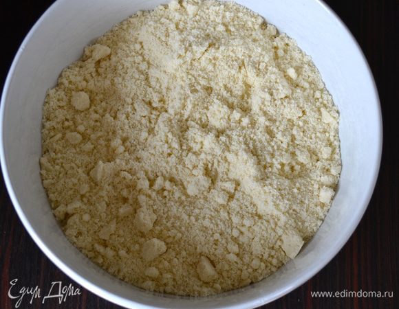 Духовку включить разогреваться на 180°C. Муку с разрыхлителем просеять в большую миску, добавить кусочки сливочного масла и втереть его в тесто до состояния крошки.