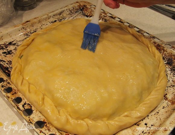 Раскатать вторую часть теста и укрыть им начинку. Защипнуть края. Смазать пирог оставшимся желтком и поставить в предварительно разогретую до 180C духовку на 1 час. Время выпечки может отличаться, все зависит от вашей духовки. Пирог готов, когда покроется румяной корочкой.