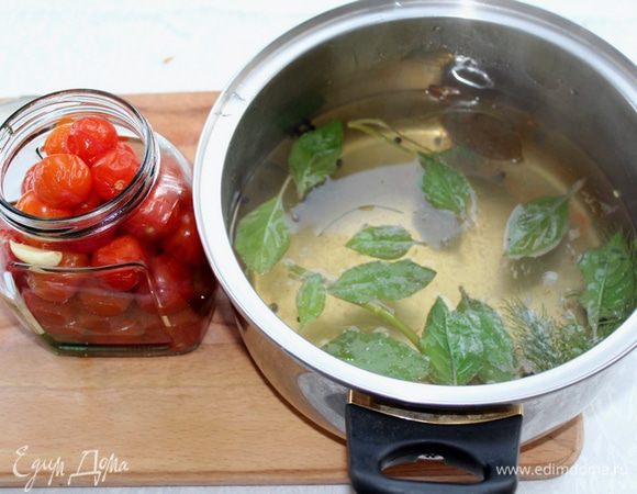 Помидоры вместе с пряностями переложите в банки, а маринад доведите до кипения. Добавьте мёд, яблочный уксус и листики базилика. 