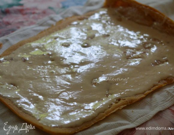 Добавить затем ванильный экстракт и размягченное сливочное масло. Взбивать до полного соединения. Выложить крем на развернутый охлажденный рулет.