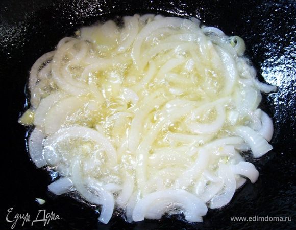 В казане нагреть подсолнечное масло, обжарить лук до золотистого цвета.