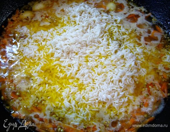 Всыпать рис поверх курицы и овощей. Накрыть крышкой и оставить на 15 мин.