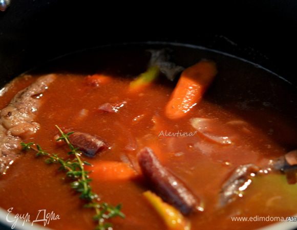 Добавить бульон, лавровый лист и тимьян. Закрыть крышкой и тушить 2 часа.