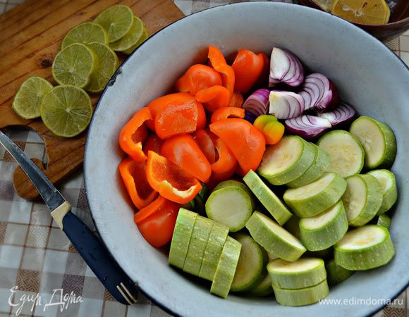 Нарежьте филе рыбы кубиками со стороной 3 см, половину лимона и лайм нарежьте тонкими кружками (крупные лимоны разрежьте на половинки или на даже четвертинки). Кабачок нарежьте кружками толщиной 0,5-0,7 см, луковицы очистите и разрежьте на четыре части. Перец очистите от семян и нарежьте кубиками примерно 4 см. 