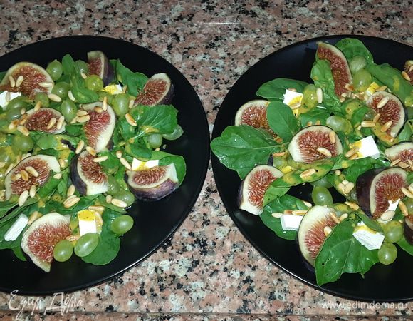 Собираем наш салат.
На большие тарелки выкладываем руколу, сверху сыр и виноград. Поливаем все заправкой, затем выкладываем дольки инжира и посыпаем орешками.
