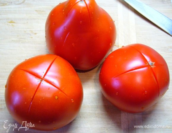 На помидорах сделать крестообразные надрезы, опустить их на минуту в кипящую воду, затем – в холодную.
