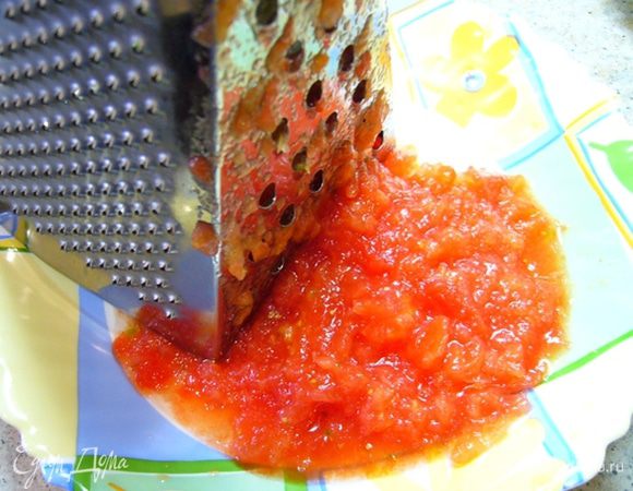 Снять шкурку, помидор натереть на крупной терке.
