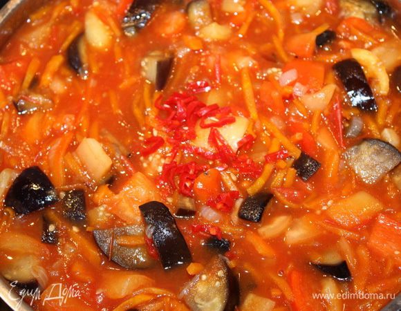 Чеснок выдавливаем через пресс для чеснока и отправляем в сотейник с овощами. Затем всыпаем соль, сахар, перец и чили перчик, все хорошо смешиваем. Тушим 20-25 минут.