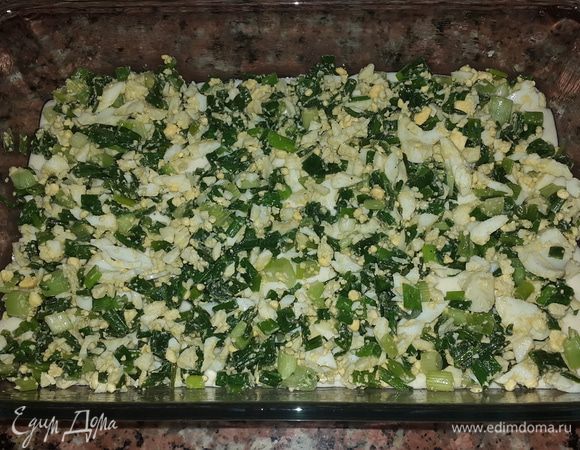 Форму для запекания смазываем оливковым маслом и выливаем большую часть теста. Сверху равномерно распределяем начинку.