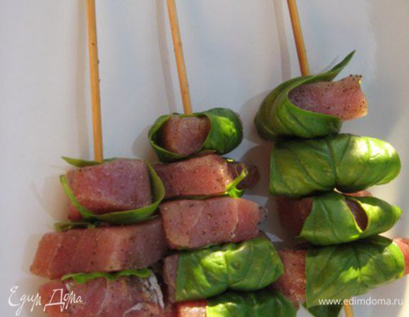 Каждый кусочек тунца завернуть в листочек базилика, надеть на шпажки по 4-5 кусочков на каждую.