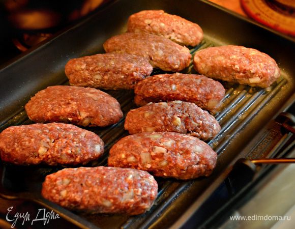 Сковороду-гриль или решётку мангала смажьте слегка маслом и выложите подготовленные колбаски.