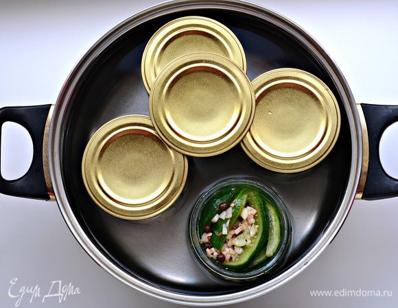 Теперь огурцы нужно простерилизовать. Для этого в большую металлическую емкость поставить банки, в емкость налить воду. С момента начала кипения выдержать 5 мин, если банки 500-граммовые; 7 мин – 700-граммовые; 10 мин – литровые.