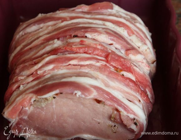 Покрываем мясо полосками бекона. Если у вас полосочки короткие, то делайте это только сверху и снизу. У меня полоски были достаточно длинные, чтобы обмотать ими весь кусок.