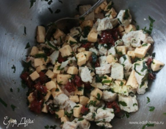 Куриное филе запекаем в фольге (можно обжарить или использовать копченую курицу), остужаем. Готовим начинку: филе режем кубиками, добавляем нарезанный кубиками сыр, нарезанные вяленые помидоры, измельченный чеснок и петрушку.