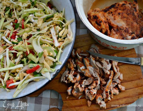 Нарезанные овощи, сыр и зелень смешать в миске. Приготовленное куриное филе нарезать на кусочки и добавить к овощам.