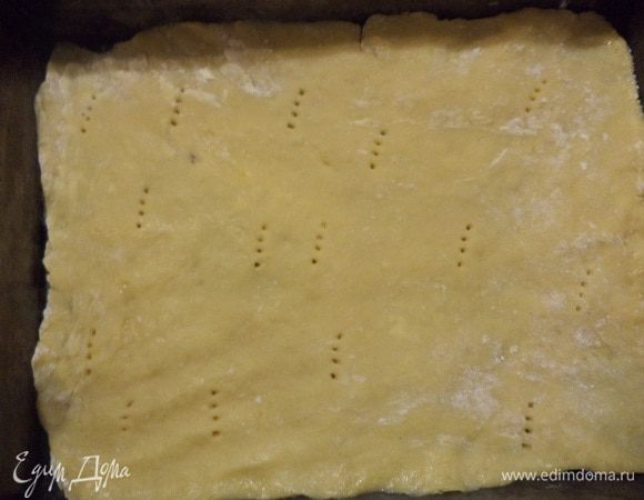 Разделить тесто на 2 равные части.
Первую часть теста раскатать в пласт по размеру формы для выпечки. Саму форму смазать маслом и выложить в неё тесто, проткнуть в нескольких местах вилкой. Выпекать 20 минут при температуре 180 градусов.