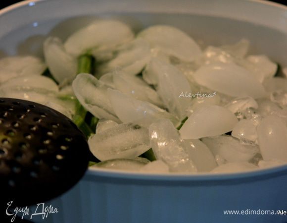 Воду слить и фасоль переложить в емкость, а сверху лед. Это делается для того, чтобы фасоль была такой же хрустящей как свежая и оставалось зеленой. Дать полежать минуту, другую. Убрать лед.