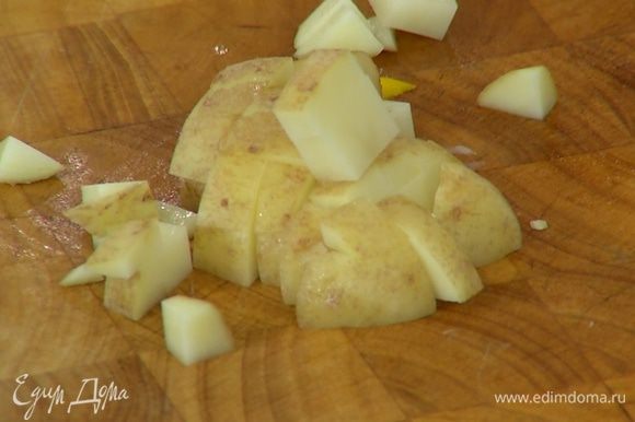 Картофель, не очищая, нарезать маленькими кубиками, выложить к овощам, посолить и перемешать.