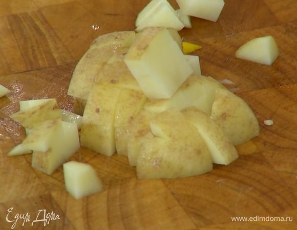 Картофель, не очищая, нарезать маленькими кубиками, выложить к овощам, посолить и перемешать.