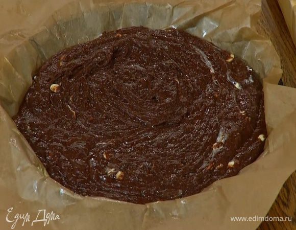 Форму для выпечки выстелить пищевой бумагой, смазать оставшимся сливочным маслом, выложить тесто и разровнять его.