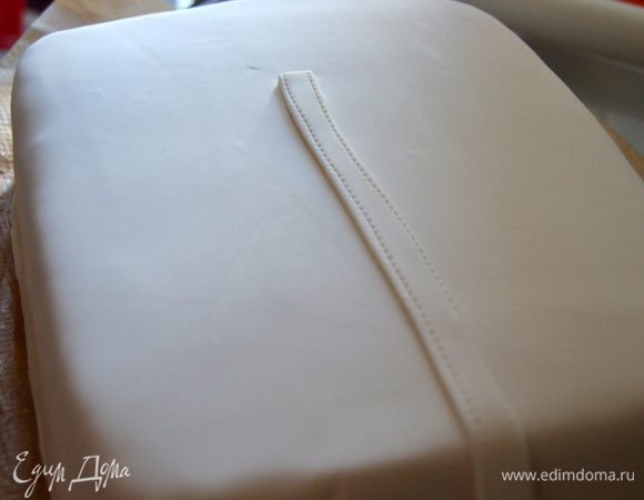 Раскатываем мастику почти в два раза больше диаметра торта. Покрываем торт, излишки обрезаем. Начинаем шить халат, делаем планку.