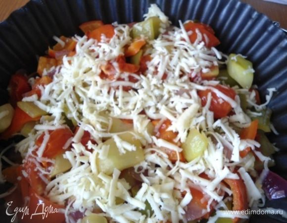 Немного остывшие овощи выкладываем в форму, посыпаем тертым сыром. 