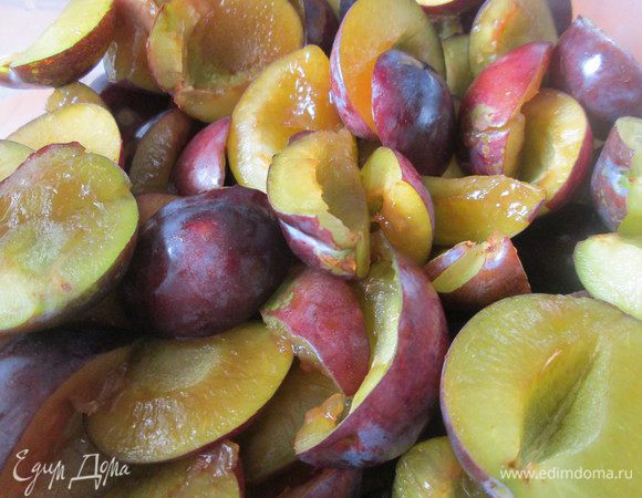 Сливы разрежьте на половинки, удалив косточки и сбрызните коньяком или ромом.