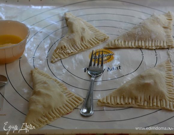 Накрыть тестом и получиться треугольник. Пройтись по краям вилкой. Слегка смазать яйцом. 