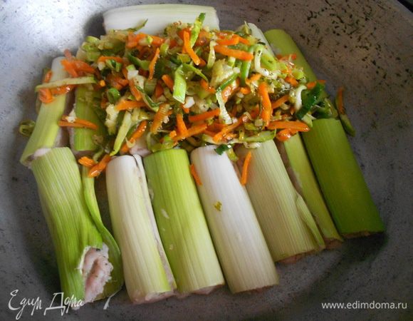 Фаршированный порей положить в форму для выпекания, добавить пассированные овощи.