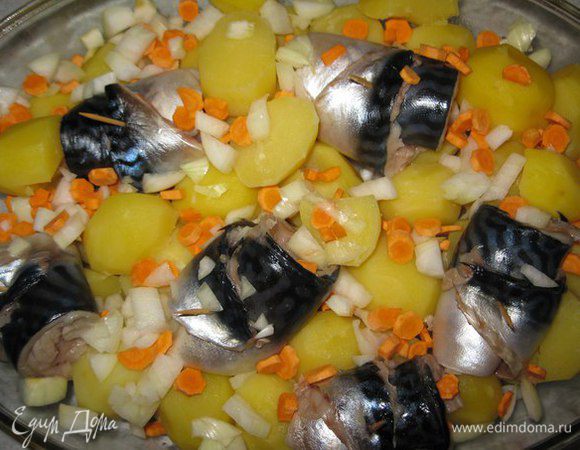 Картофель выложить в форму для запекания. Рулетики из скумбрии на картофель. Наверх морковь и лук.