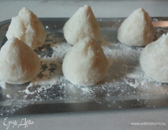 Берем немного теста, в руках расплющиваем в лепешечку, кладем начинку, защипываем и придаем форму трюфеля.