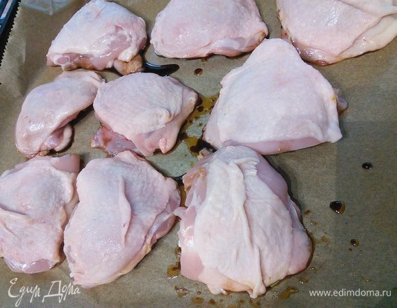Куриные части обмакните нижней стороной в маринаде. Выложите на противень. 