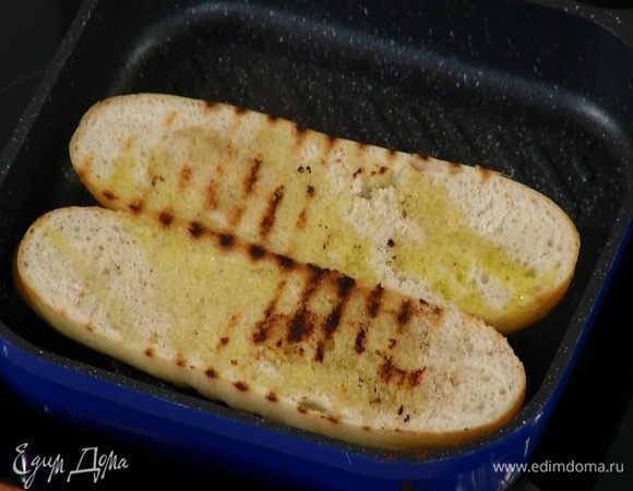 В сковороду-гриль, где жарилась грудинка, выложить половинки багета срезами вниз и обжаривать до появления золотистых полосок.
