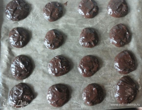 Когда шоколадная смесь немного остынет, все быстро и аккуратно смешиваем и выкладываем на противень, покрытый пекарской бумагой и смазанный сливочным маслом. Стараемся, чтобы по размеру и по форме печеньки были примерно одинаковые. 