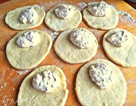 Накладываем на кружочки ближе к краю чайную ложку начинки.