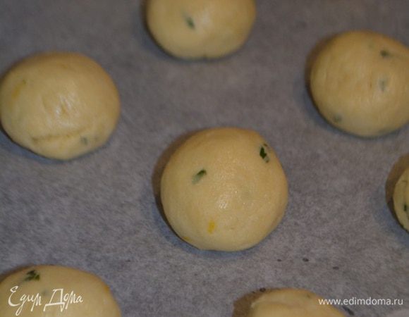 По истечение времени достать тесто. Отщипывать от него небольшие кусочки, скатать шарики (размер грецкого ореха) и уложить на противень, выстланный пекарской бумагой.