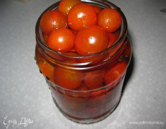 В сухие и стерилизованные банки на дно кладем листья хрена (в ингредиентах я выбрала листья смородины, хрена не нашла). Перец горошком, порезанный чеснок и черри.