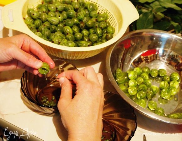 Подготовить крыжовник. Для этого у каждой ягодки обрезать ножничками хвостики с обоих концов и сделать продольный разрез сбоку. Когда проделаете эту операцию со всеми ягодами, возьмите шпильку и закругленным концом удалите семена из каждой ягоды в отдельную посуду (я потом эту массу использовала в компот).