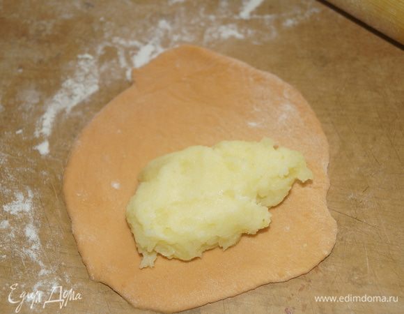 Разделать тесто на небольшие кусочки, из которых сформировать шарики. Каждый шарик раскатать в лепешку и положить на нее начинку.