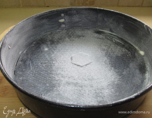 Форму, для уверенности безпроблемного изъятия в последствии из нее готового пирога, смазываем сливочным маслом и присыпаем мукой. Излишки стряхиваем и включаем разогреваться духовку на 180-190 градусов.
