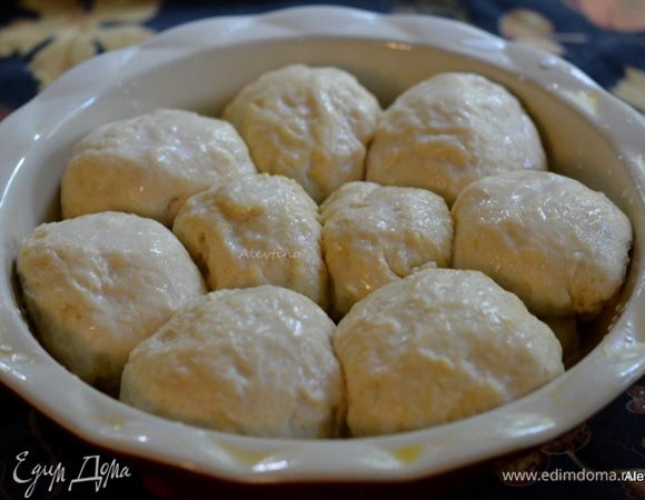 Разделить тесто на 8-9 равных частей. Скатать шариками и выложить в приготовленную смазанную форму. Прикрыть и поставить в теплое место на расстойку 45 минут. Булочки на это время поднимутся и вырастут.