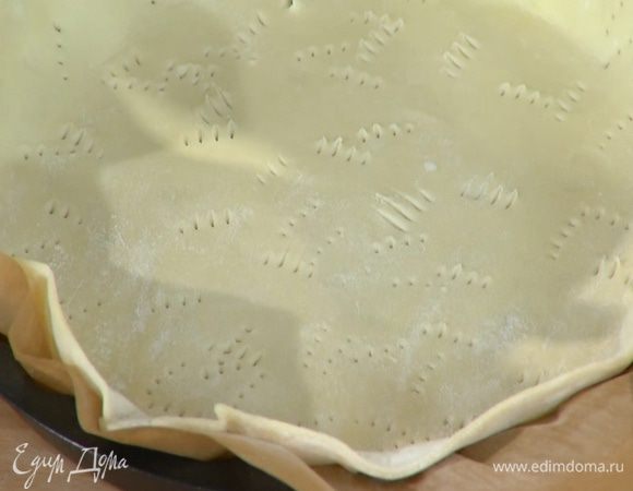 Форму выстелить бумагой для выпечки, выложить тесто, сформировав бортики, и часто наколоть его вилкой.