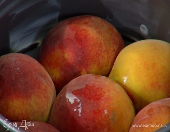 Персики разрезать пополам и, удалив косточки, уложить в форму срезами вниз.