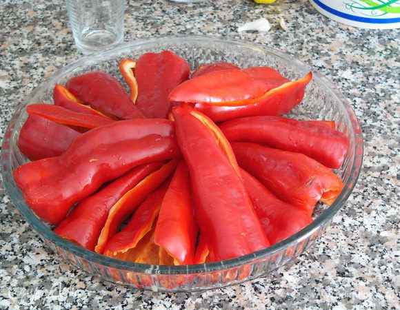 Мясистый перец вымыть и запечь. Можете сделать это привычным вам способом, а можете, как я в этот раз, воспользоваться советом бывалого кулинара. Разрезать перец на 2 части, вычистить семена, выложить перец на противень или большое блюдо для запекания, сбрызнуть оливковым маслом и посыпать солью. Поставить в разогретую до 200 градусов духовку на 30-40 мин.   

Такой вариант запекания понравился мне тем, что перец получается уже очищенным (вычистить семена у сырого перца намного проще) и ровно нарезанным. Это пригодится нам на следующем этапе. 